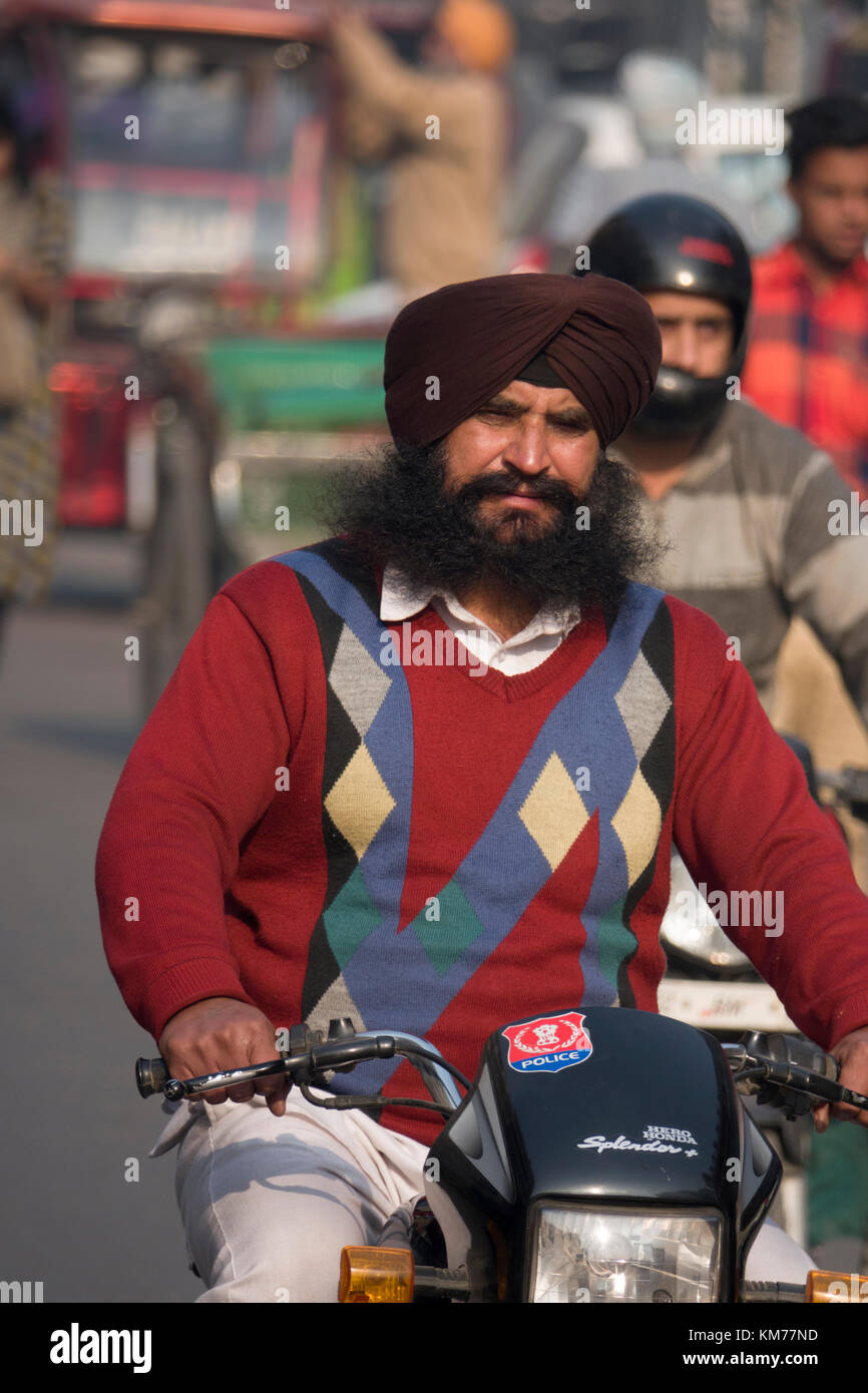 Punjabi sikh Mann mit langem Bart und Turban reiten Motorrad in Amritsar, Punjab Stockfoto