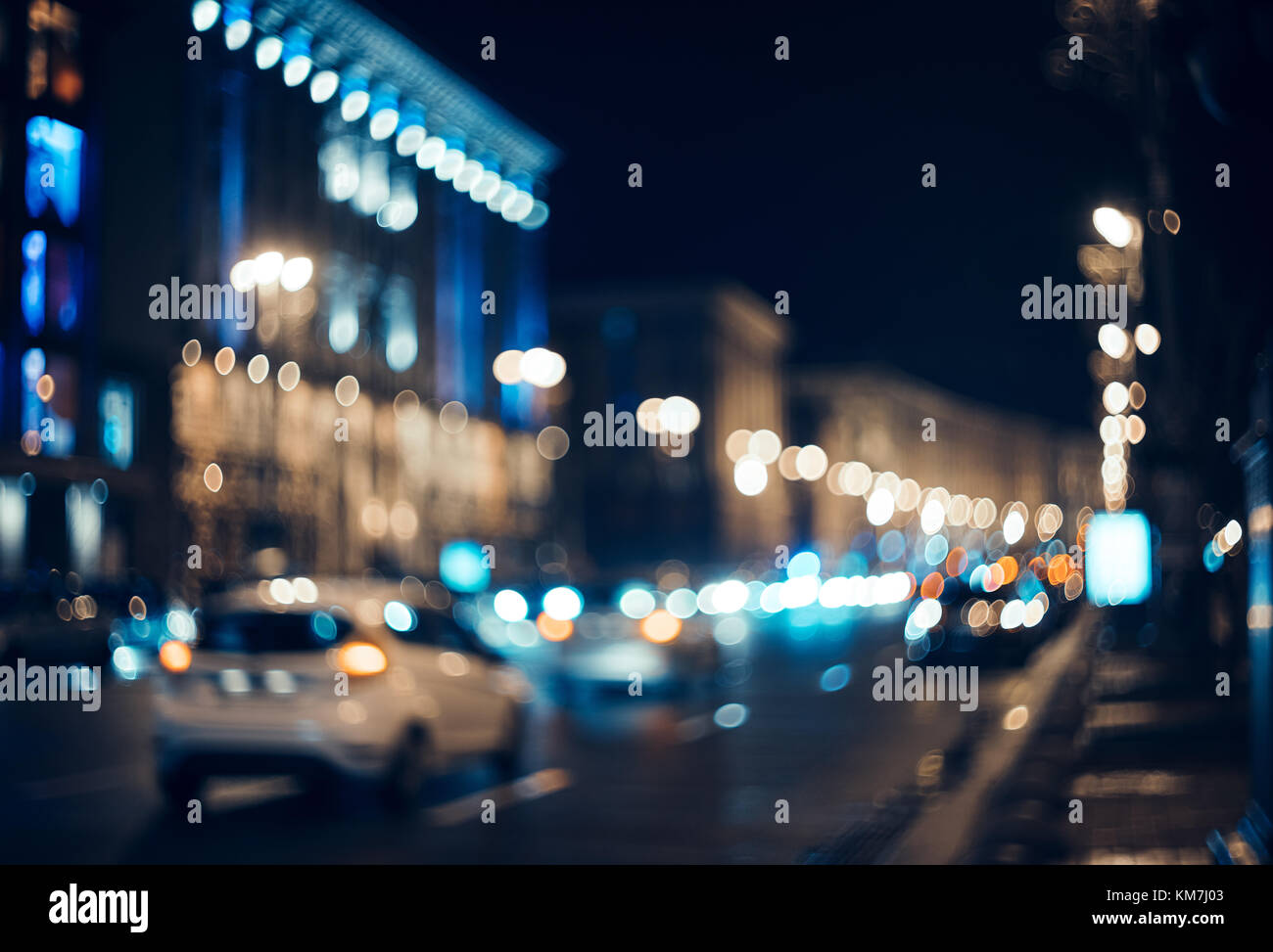 Verschwommen Stadt bei Nacht. Bokeh. Schöne Zusammenfassung Hintergrund mit Defokussierten Gebäude, Autos, City Lights, Leute. Bunte bokeh Hintergrund mit städtischen Stockfoto