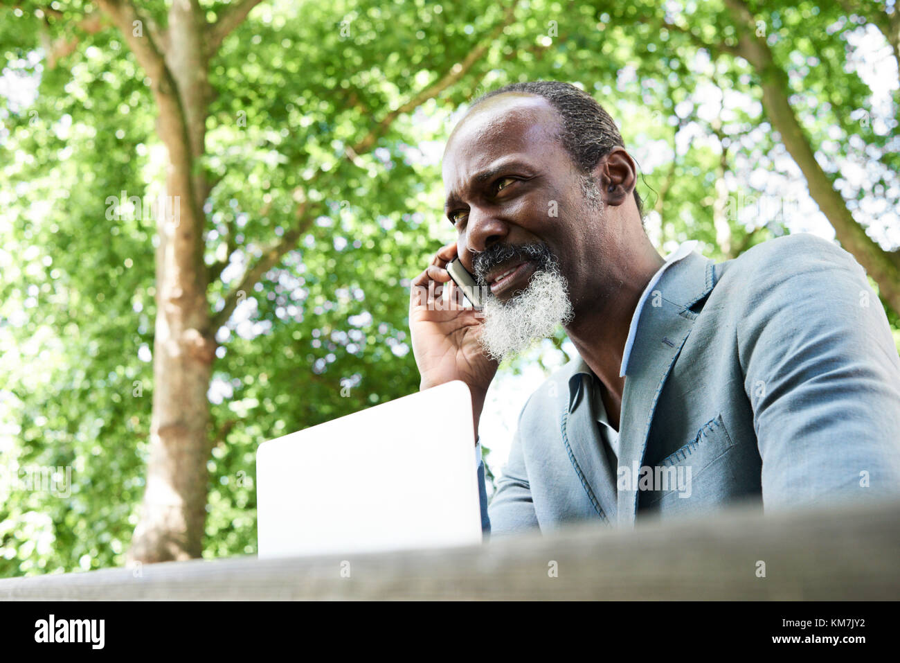 London, UK, über 50 s Schwarz afrikanische Mann plaudern über das Telefon im Freien, single. Stockfoto