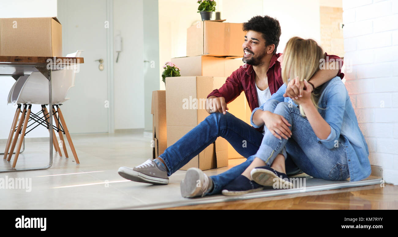 Junge glückliches Paar Umzug in neues Zuhause und Auspacken der Kartons Stockfoto