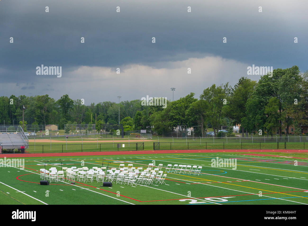 Leere Band Stühle auf Fußballfeld mit Approaching Storm Stockfoto