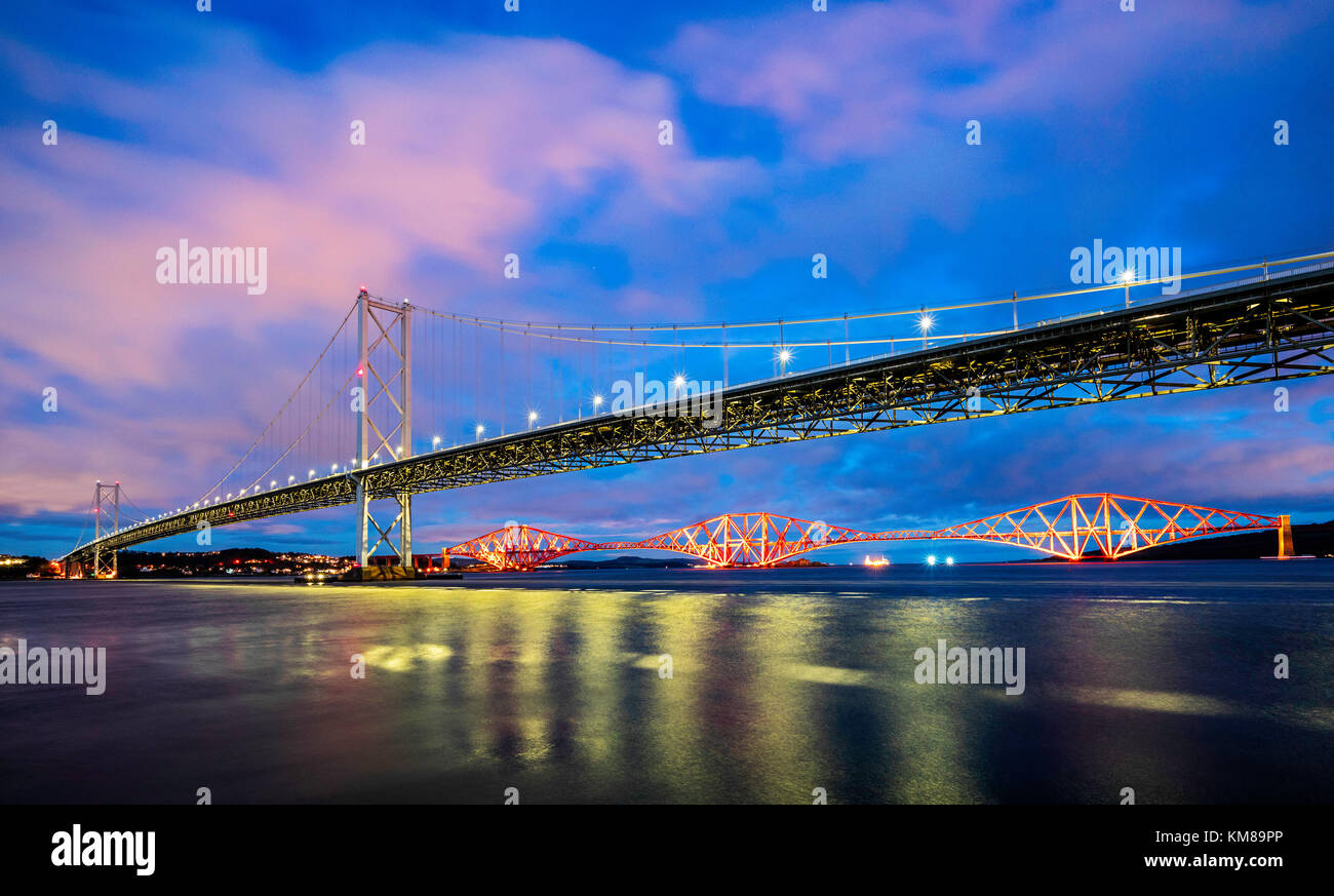 Nachtansicht der Forth Road Bridge und der Forth Bridge (Eisenbahn) über den Firth of Forth bei South Queensferry in Schottland, Großbritannien Stockfoto
