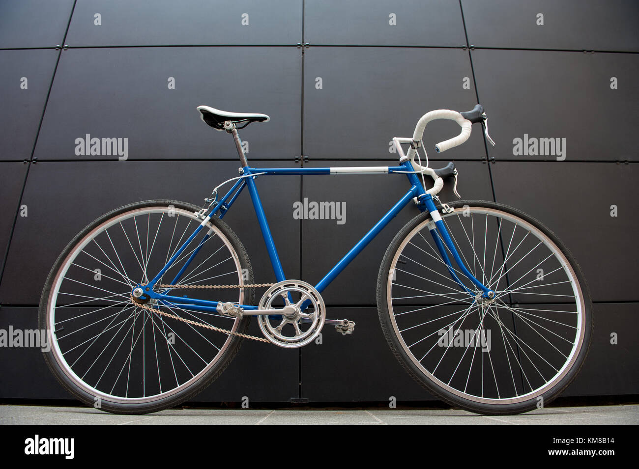 Vintage Blau und Weiße Stadt Fahrrad auf eine schwarze Wand. Rennrad  Stockfotografie - Alamy