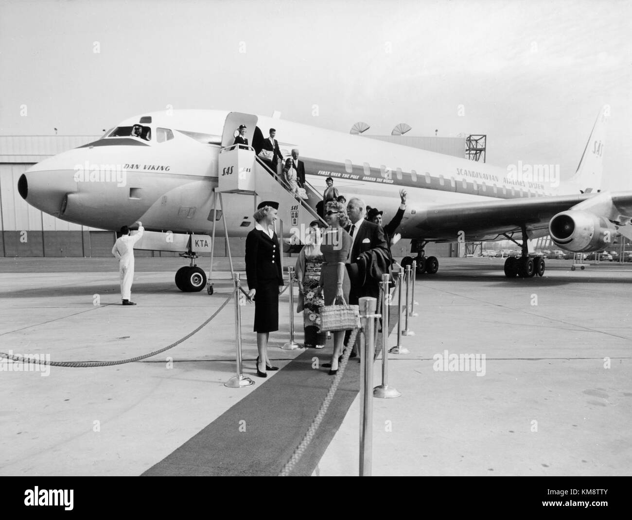 Die SAS DC 8 33, ein bedeutendes Modell der 1960er Jahre, ist am Boden abgebildet, wobei Bodendienste stattfinden, insbesondere die Dan Viking-Variante. Stockfoto