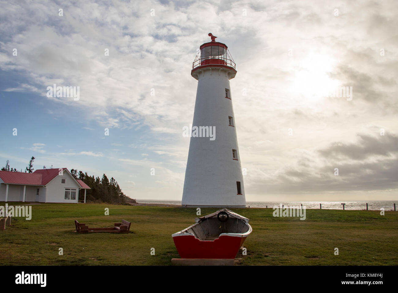 Leuchtturm am Point Prim mit hölzernen Ruderboot auf Prince Edward Island, Kanada gegen bewölkt blauer Himmel an einem sonnigen Tag. Stockfoto