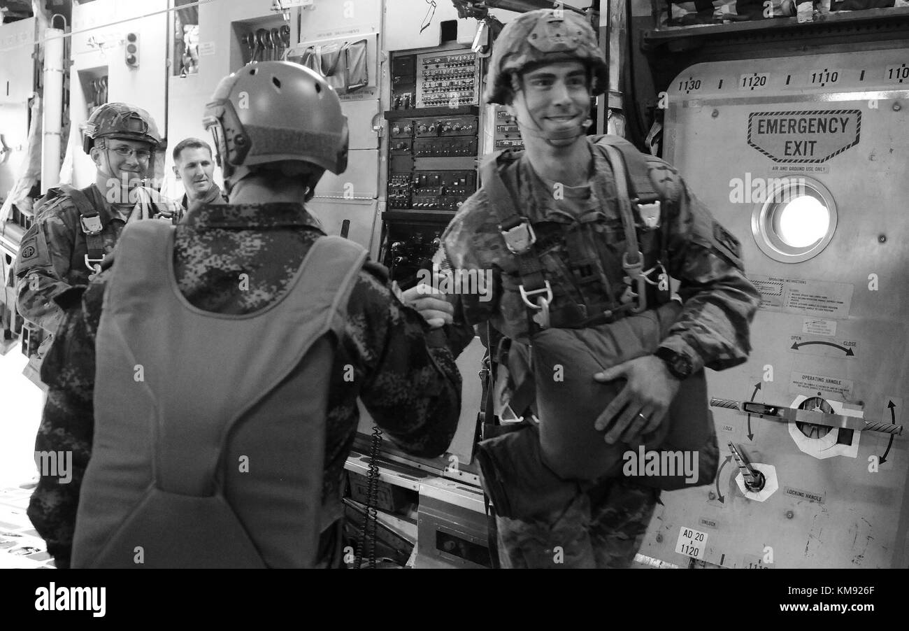 Kolumbianische Jumpmaster Staff Sgt. Dario A. Bayona mit dem kolumbianischen Battallon Fuerzas Especiales #4 schüttelt die Hände mit Fallschirmjägern, als sie an Bord des C-17 Globemaster III während der 20. Jährlichen Randy Oler Memorial Operation Toy Drop 2. Dezember 2017 gehen. Die Operation Toy Drop ist die weltweit größte kombinierte Luftoperation mit acht teilnehmenden Partnernationsparatrooperatoren und ermöglicht Soldaten die Möglichkeit, ihre militärische Berufsspezialität zu trainieren, ihre Luftbereitschaft aufrecht zu erhalten und der lokalen Gemeinschaft etwas zurückzugeben. Stockfoto