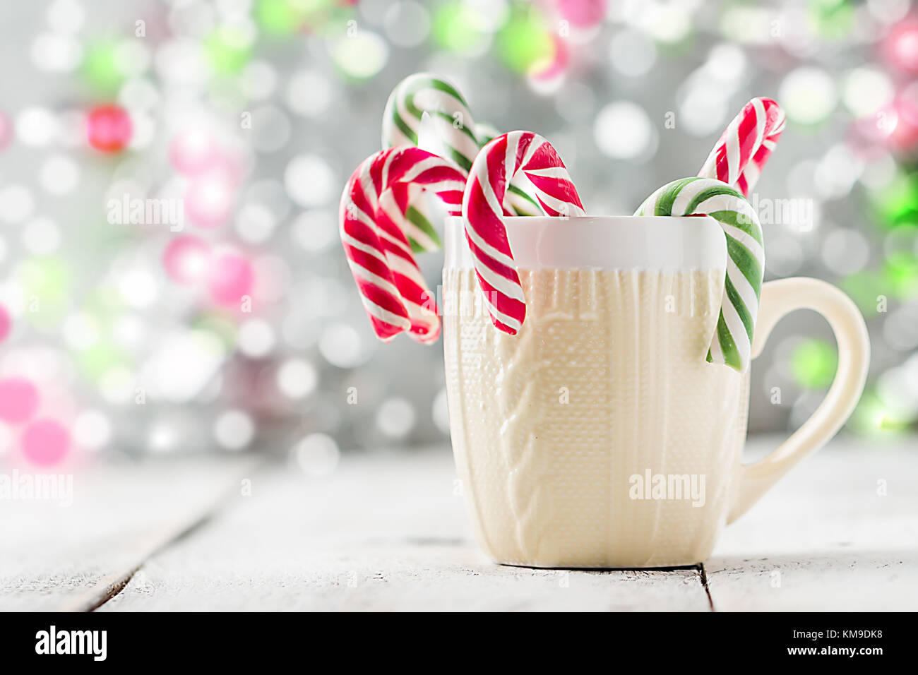 Einen gestrickten drucken Schale mit Weihnachten Bonbons vor der weißen bokeh Hintergrund Stockfoto