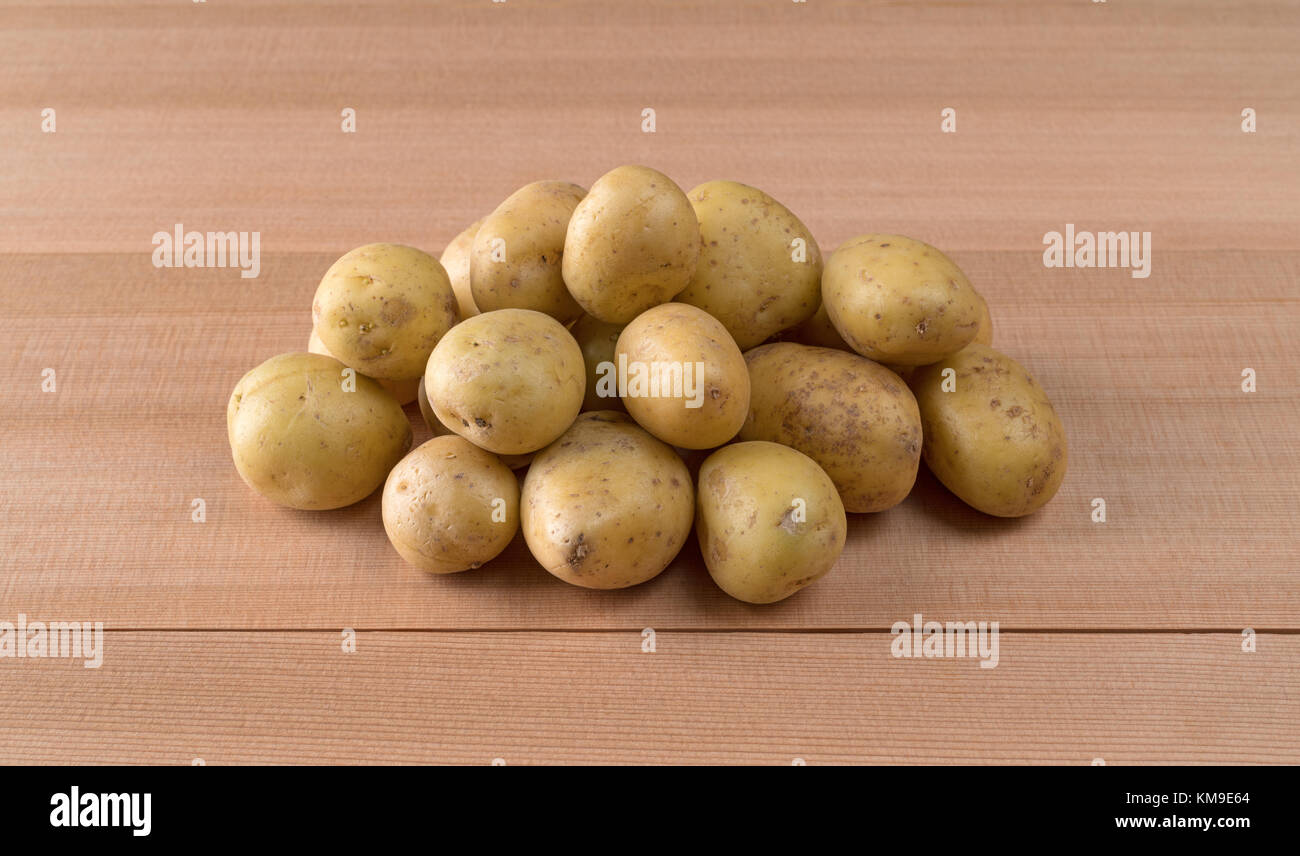 Ein kleiner Haufen von Gold baby Kartoffeln auf einer Zeder Zähler nach oben. Stockfoto