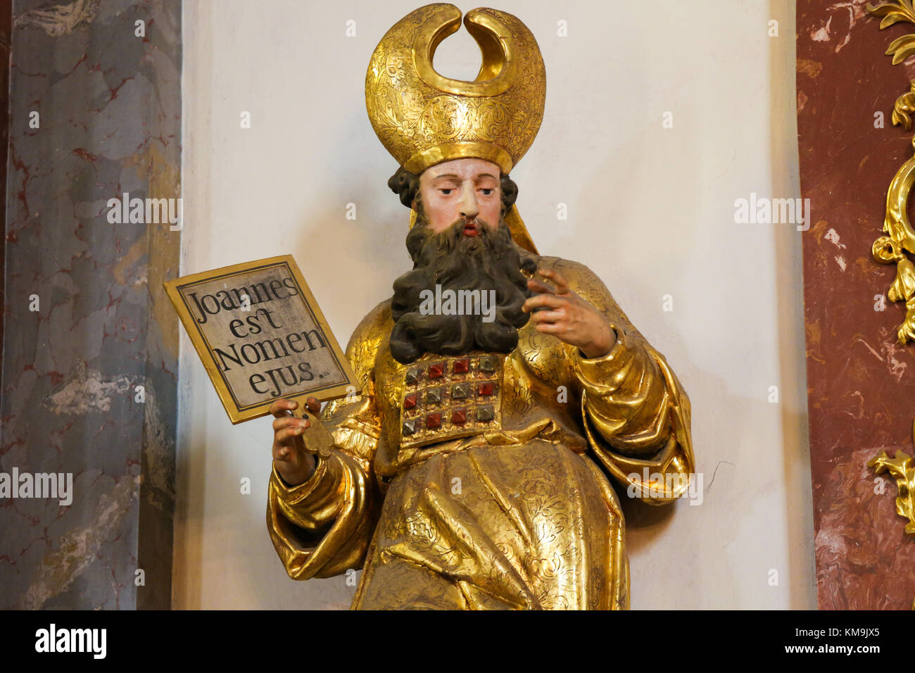 Statue eines Heiligen mit einem Schild mit den lateinischen Text Joannes est Nomen Ejus oder Johannes ist sein Name, die sich auf den hl. Johannes der Täufer, in der Loreta Kirche in Stockfoto