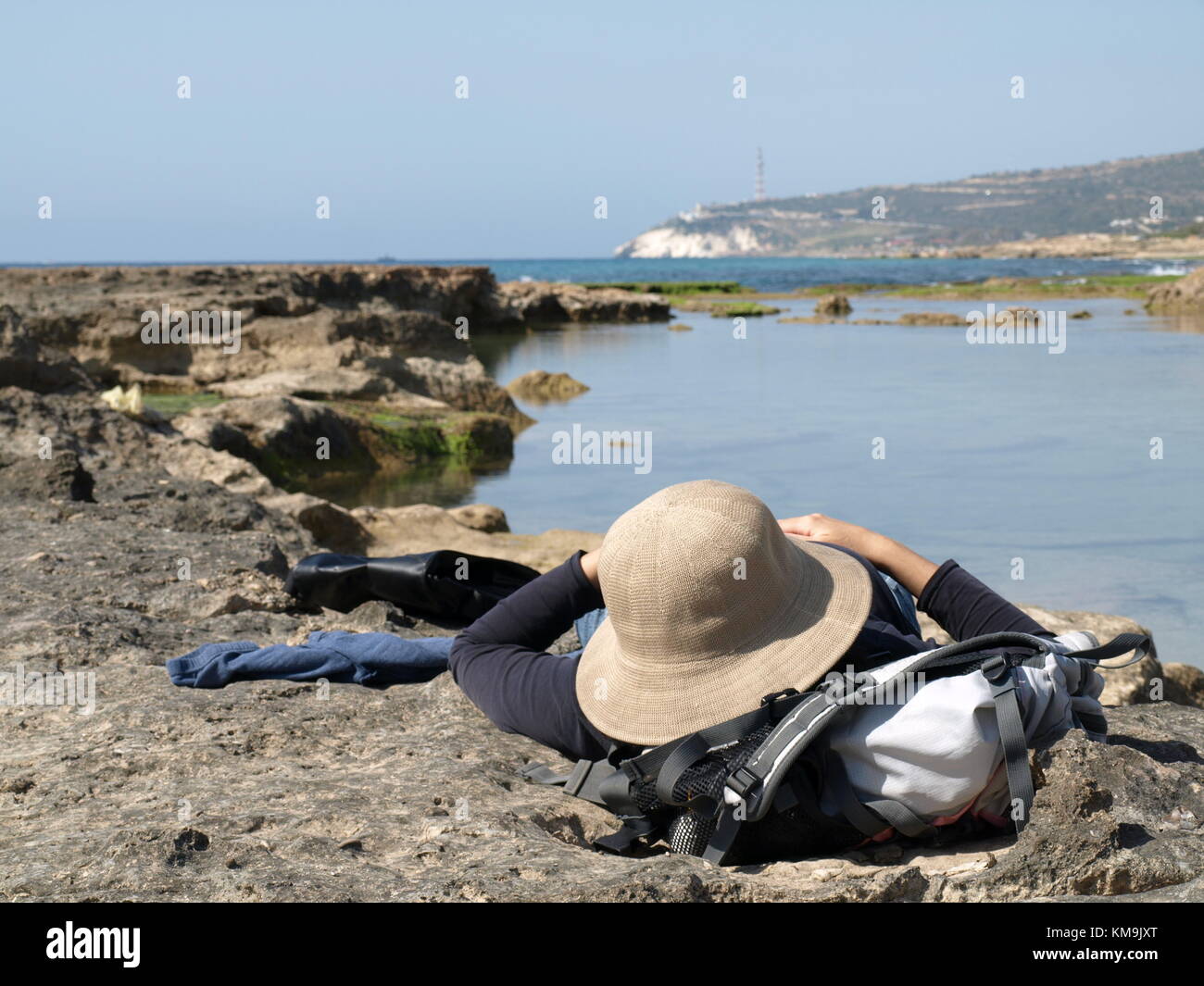 Wanderer ist ruhen oder schlafen auf den Felsen in der Nähe des Meeres Stockfoto