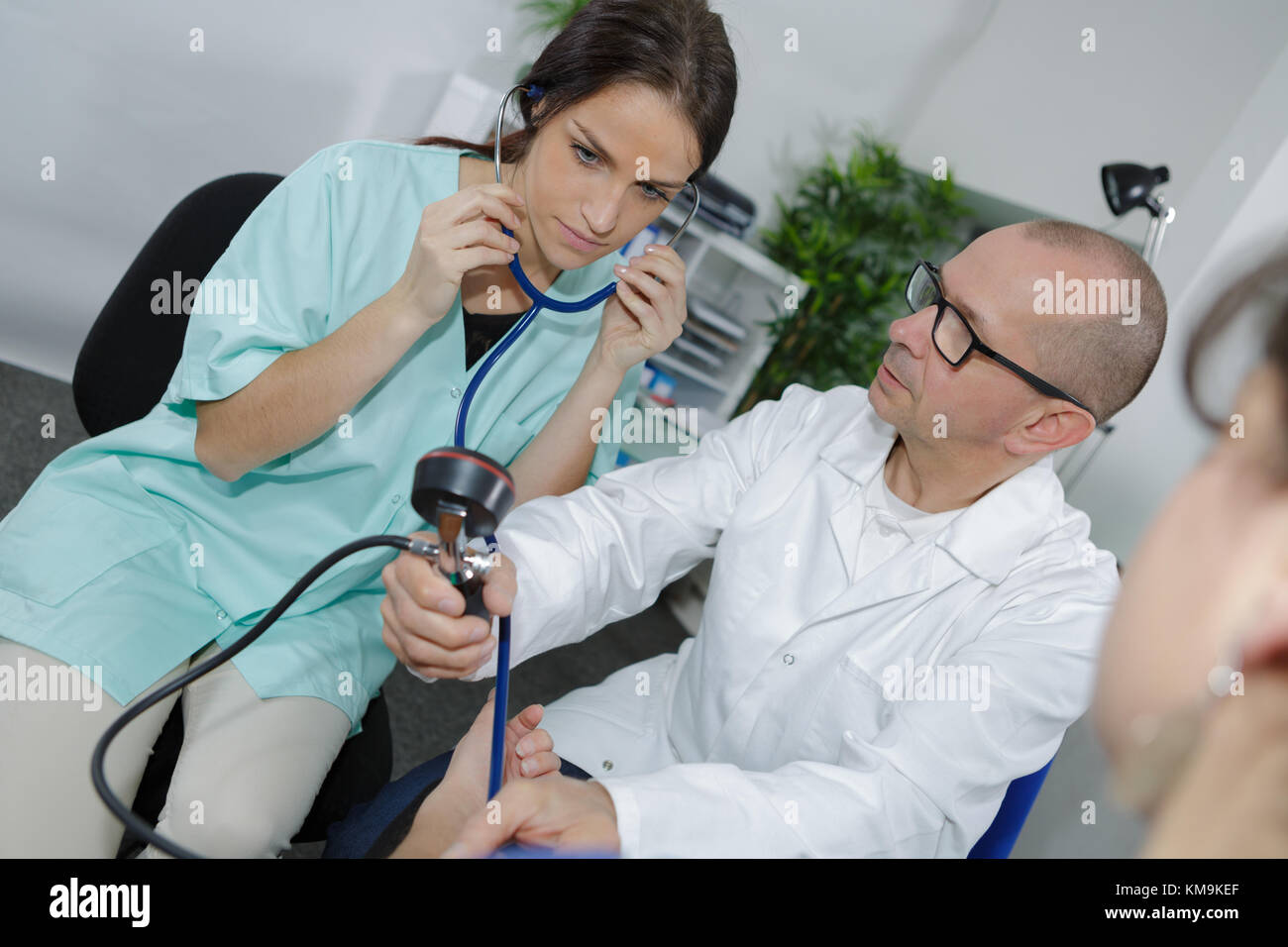 Ziemlich internist ausculting Patienten mit erfahrenen Arzt Stockfoto