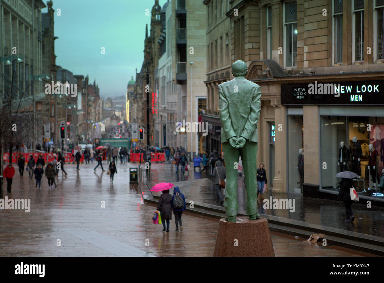 Rosa Regenschirm Donald Dewar statue Royal Concert Hall Buchanan Galleries der Stil Meile regnerischen Tag nass Sauchiehall street, Glasgow, Vereinigtes Königreich Stockfoto