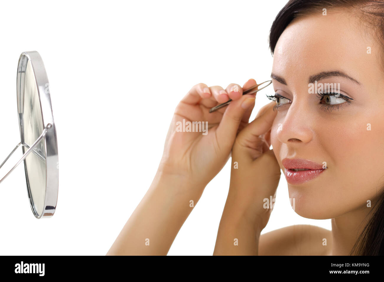 Schöne junge Frau Zupfen der Augenbrauen, im Spiegel zu betrachten Stockfoto