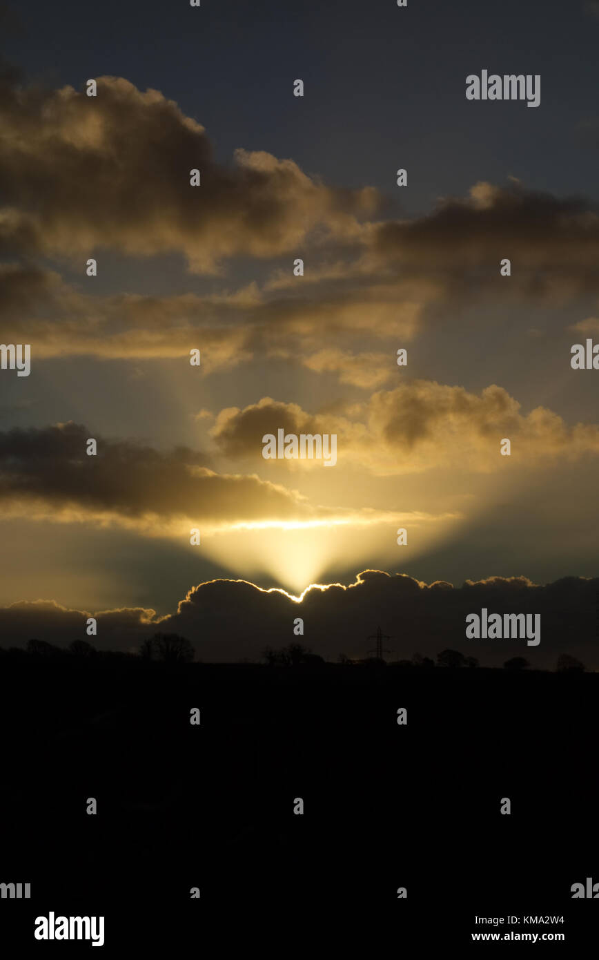 Lightrays aus die Sonne hinter ein paar Wolken Stockfoto