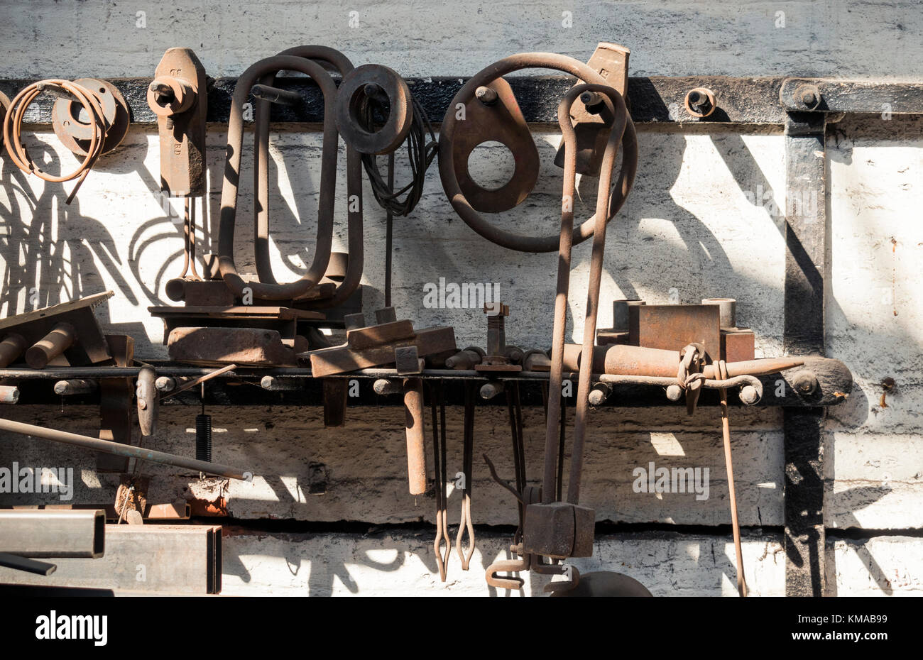 Tools und verschiedene Metall Arbeiten an der Wand hängen von einer Werkstatt in Underfall Yard, Bristol Stockfoto