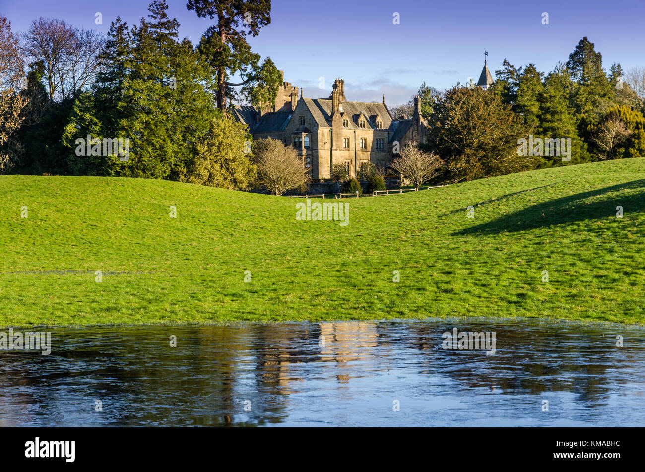 Ein englisches Herrenhaus mit gefrorenem Wasser im Vordergrund. Stockfoto