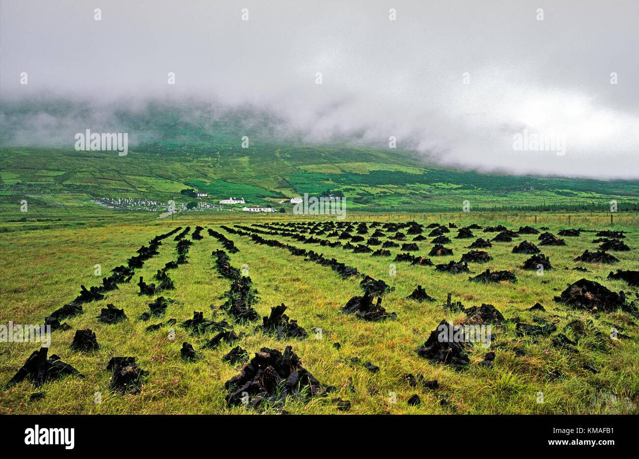 Torf Rasen gestapelt, um Kraftstoff unter Nebel trocknen abgedeckt Slievemore Mountain auf Achill Island, County Mayo, West-Irland. Stockfoto