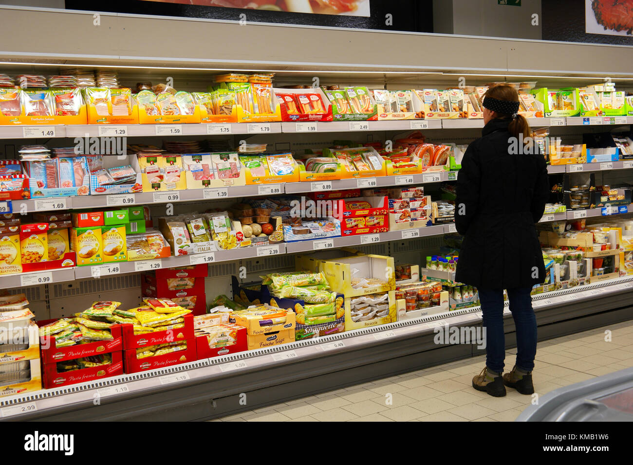 Shopping Frau sucht frisches Produkt in gekühlten Abschnitt eines Supermarkts. Stockfoto