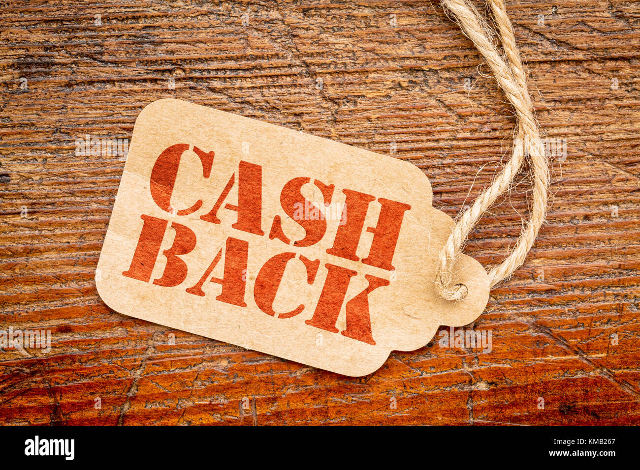 Cash Back Zeichen - Rot stencil Text auf einem Karton preis Tag gegen rustikalen, mit Holz Stockfoto
