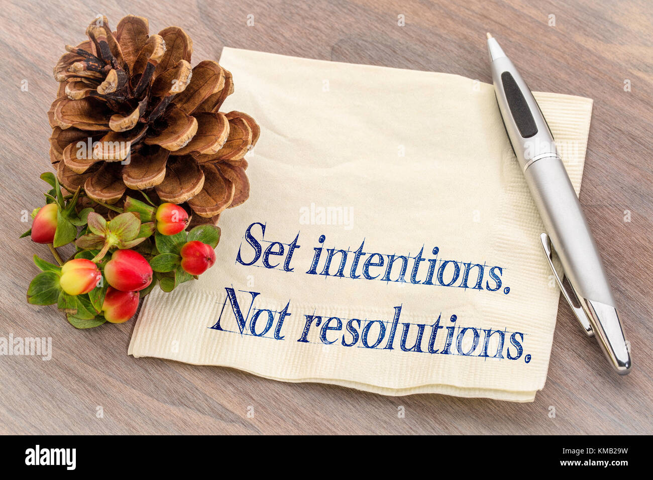 Set Absichten. Nicht Resolutionen. Neues Jahr Ziele Konzept. Handschrift auf eine Serviette mit einem Tannenzapfen. Stockfoto