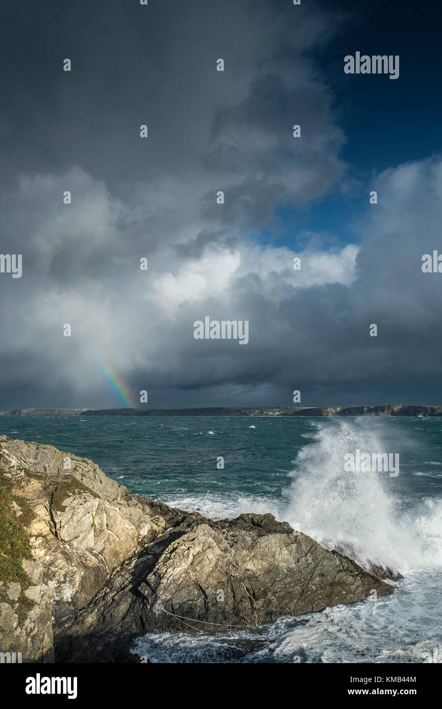 UK Wetter - stürmisches Wetter und ein Regenbogen nähert sich Newquay an der North Cornwall Küste. Stockfoto