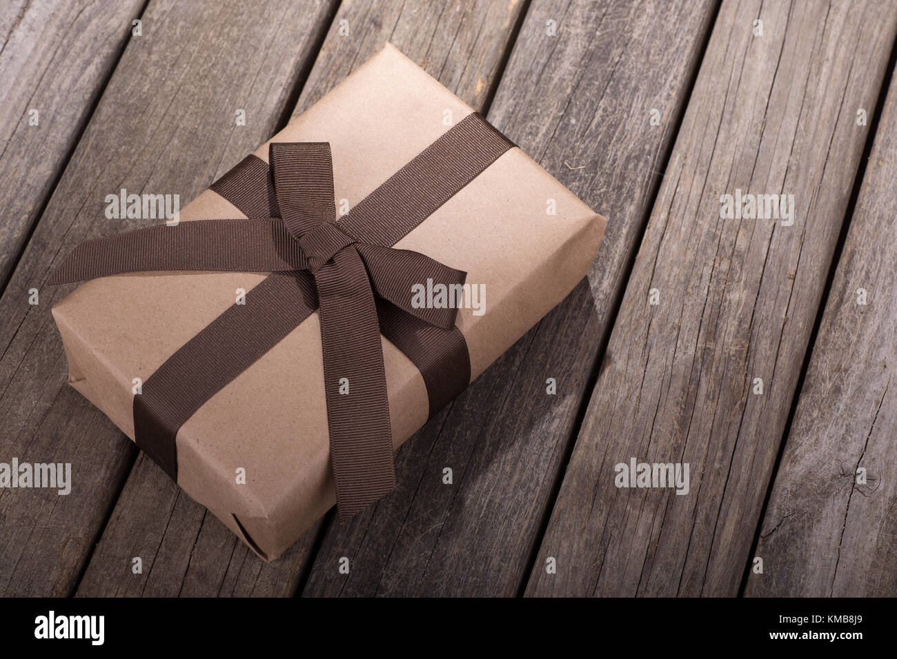 Braun Geschenk Paket auf einem alten Holz Oberfläche Stockfoto