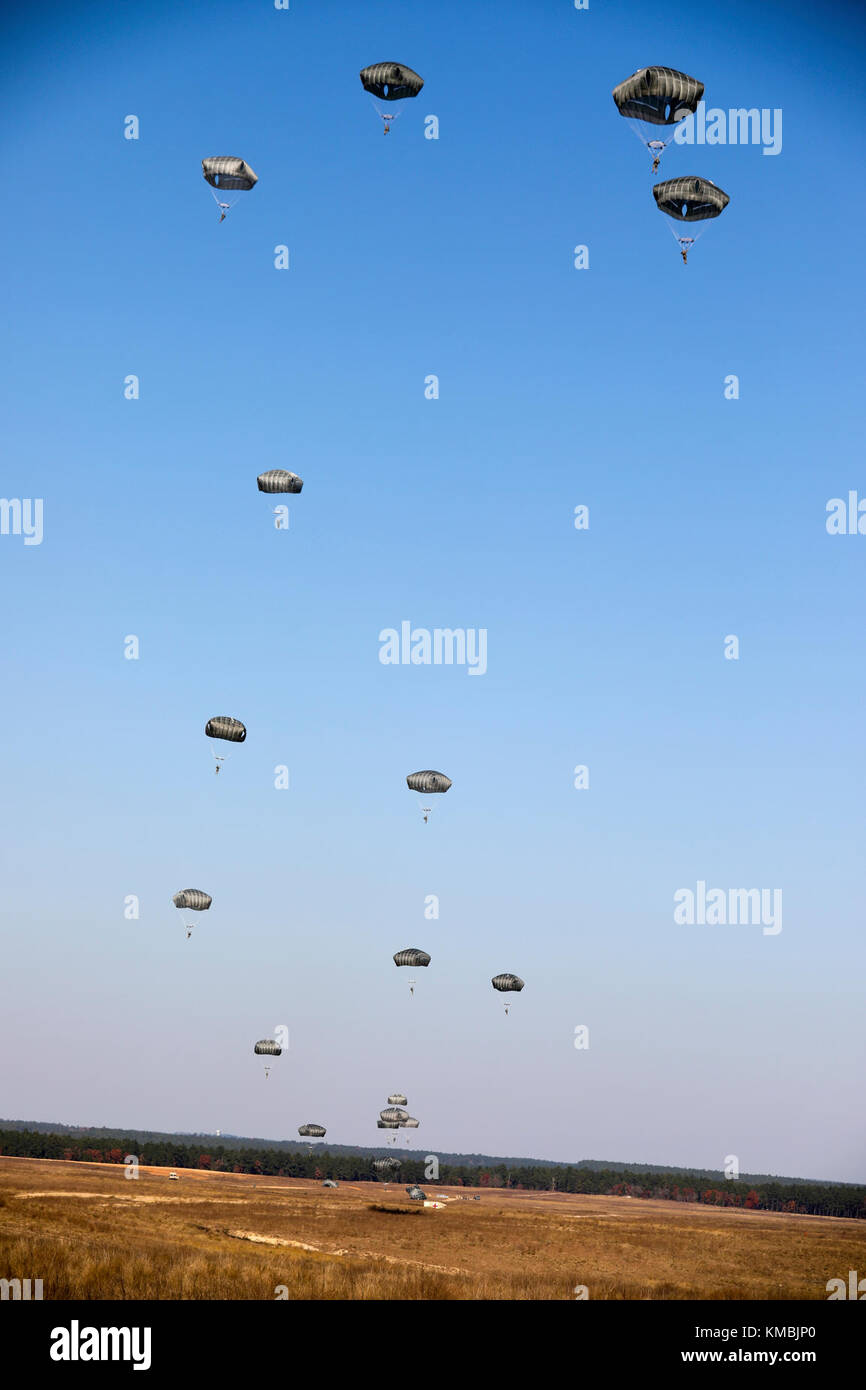 Fallschirmjäger füllen den Himmel in der Sicily Drop Zone für die 20. Jährliche Randy Oler Memorial Operation Toy Drop, veranstaltet von U.S. Army Civil Affairs & Psychological Operations Command (Airborne) 1. Dezember 2017 in Fort Bragg, North Carolina. Operation Toy Drop ist die weltweit größte kombinierte Luftoperation und ermöglicht Soldaten die Möglichkeit, auf ihre militärische berufliche Spezialität trainieren, ihre Luftbereitschaft aufrecht zu erhalten, und geben zurück an die lokale Gemeinschaft. (USA Armee Stockfoto