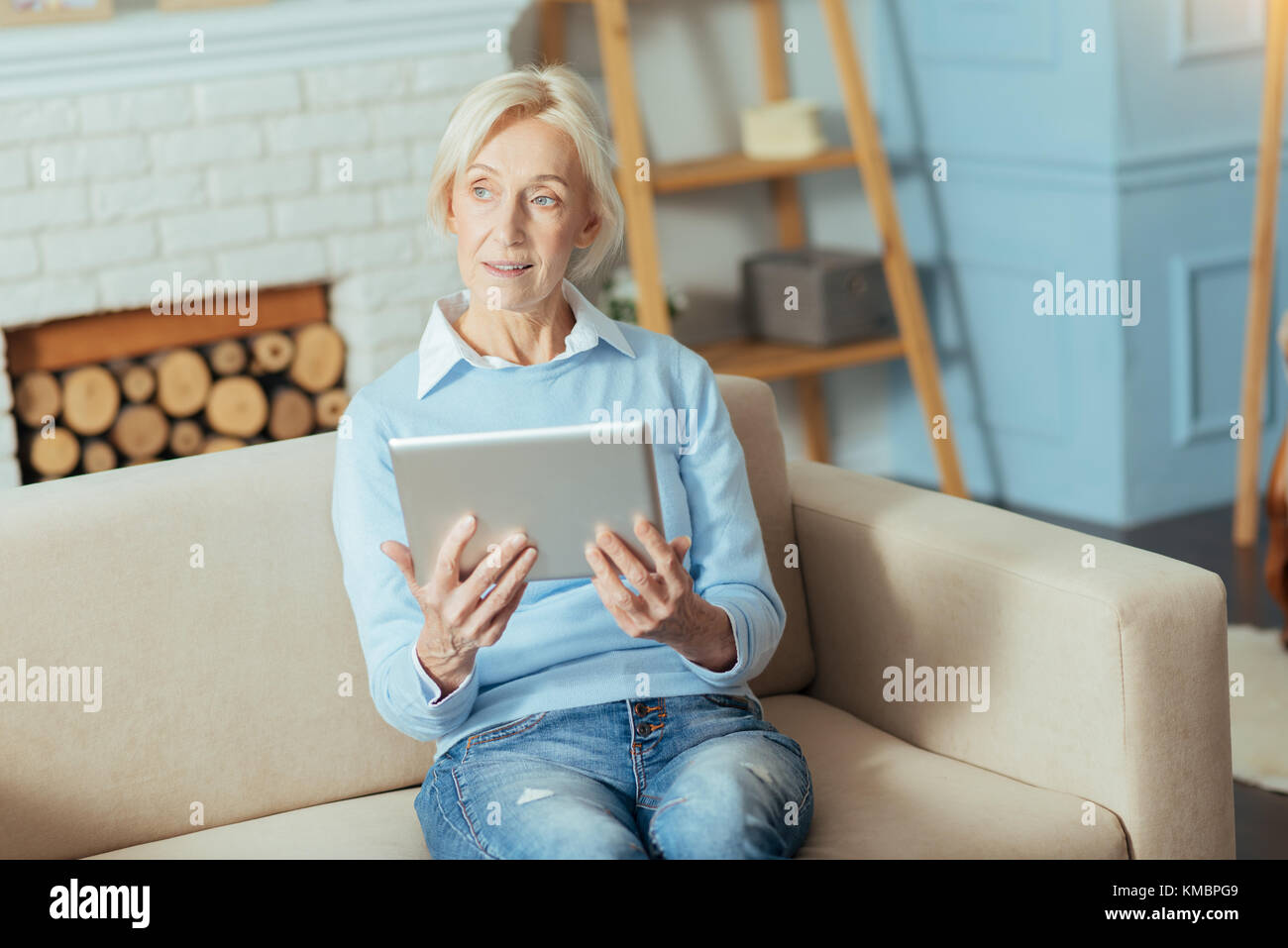 Smart ruhig Rentner sitzen mit einem modernen Gadget und Denken Stockfoto