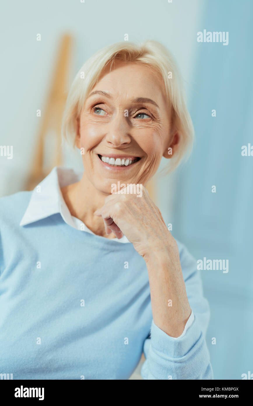 Glücklich im Alter von Frau sitzt und fröhlich lächelnd Stockfoto