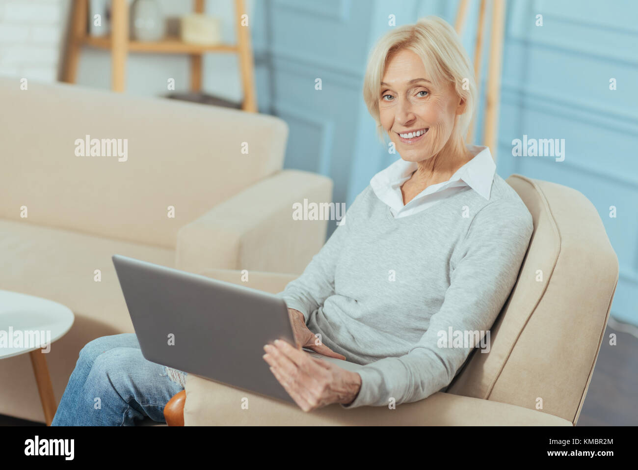 Gerne ältere Frau froh, dass während eines großen Laptop Stockfoto