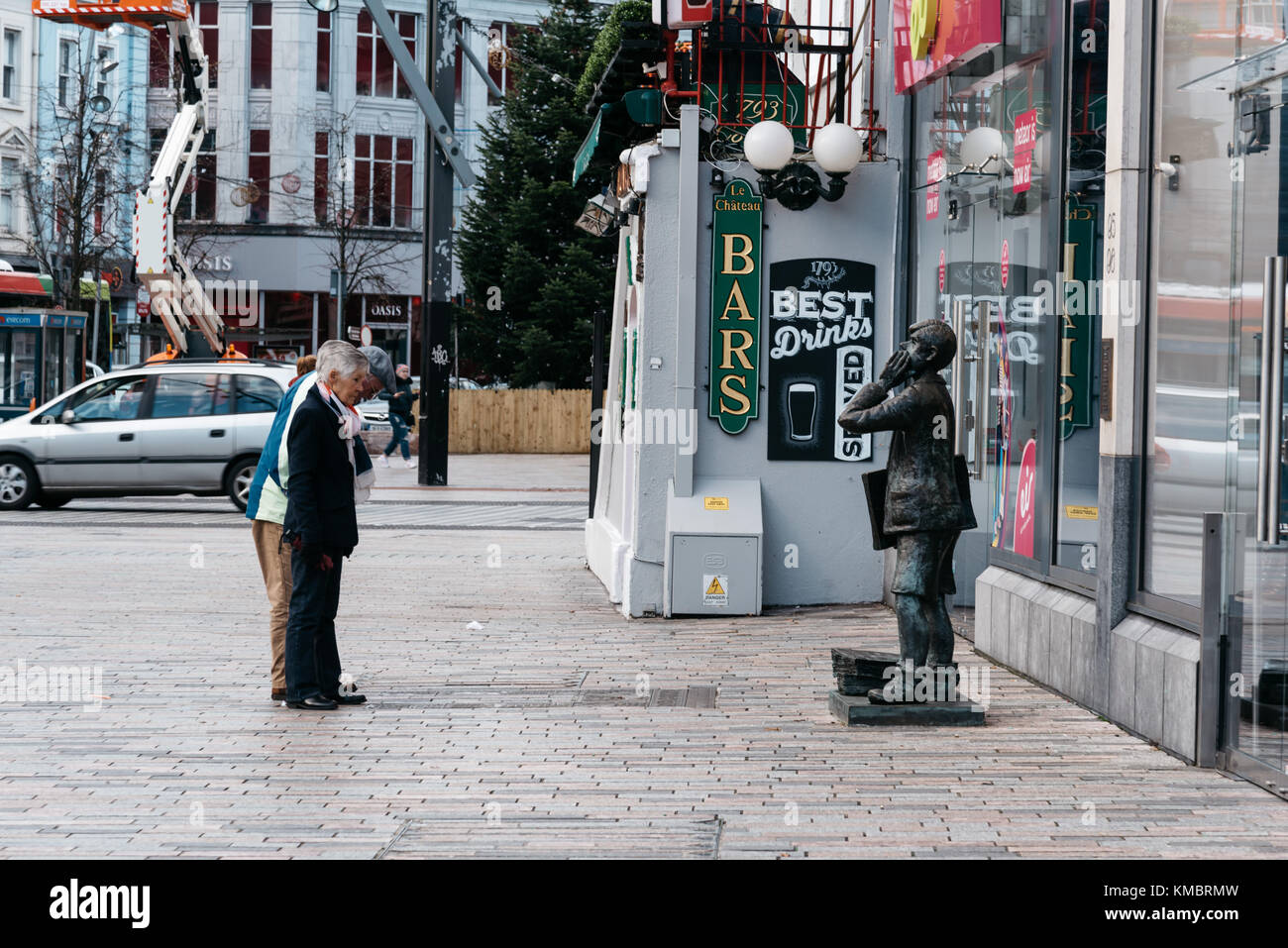 Leute, die sich vor der Statue, die in der St Patrick Street in Cork Stockfoto