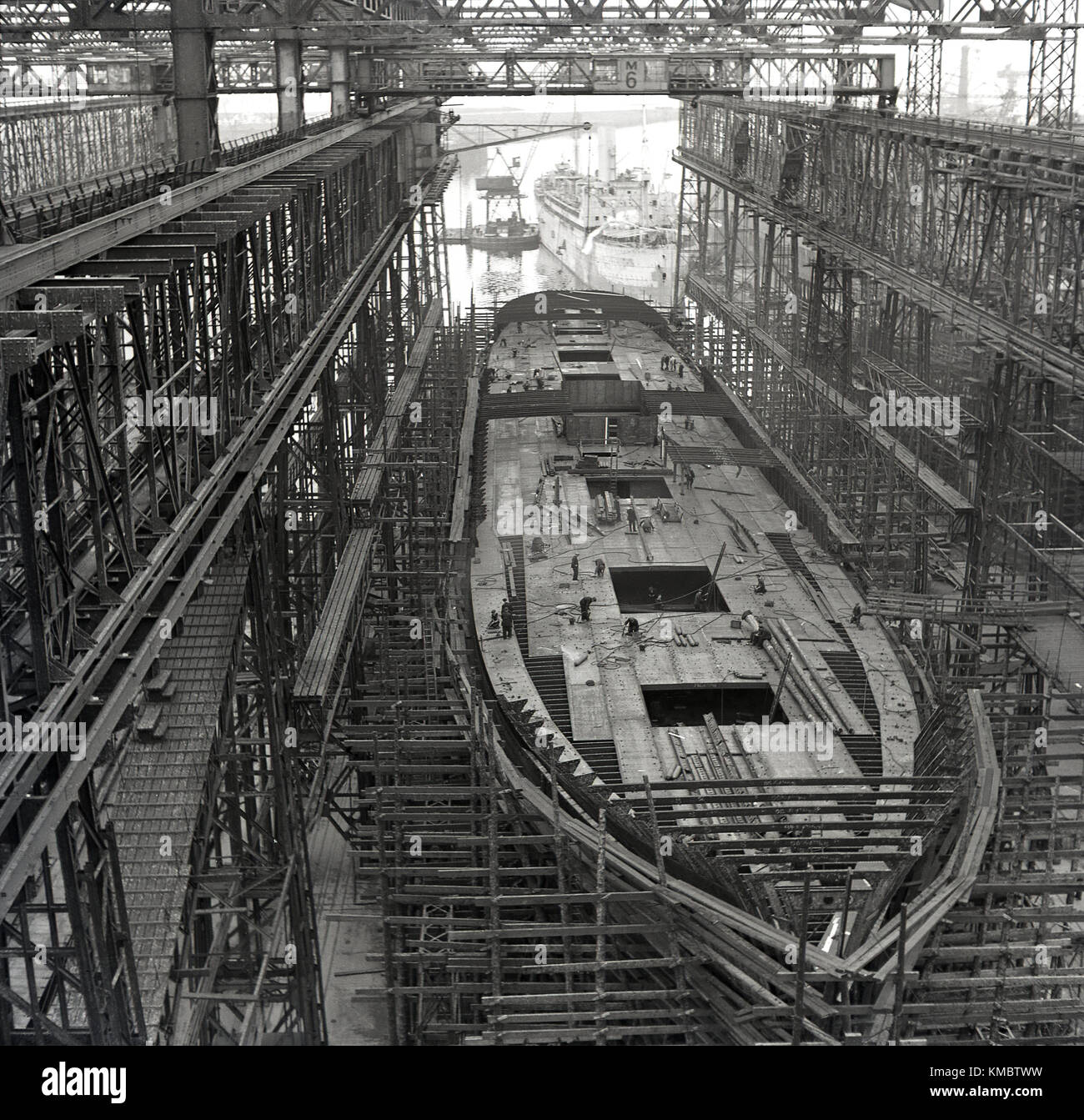 1950er Jahre, historische Bild eines Schiffes im Bau in einem trockendock unter dem Arrol Gantry an der berühmten Harland und Wolff Werft, wo die Titanic und anderen großen Olympischen - Kategorie Schiffe gebaut wurden, Belfast, Nordirland. Stockfoto