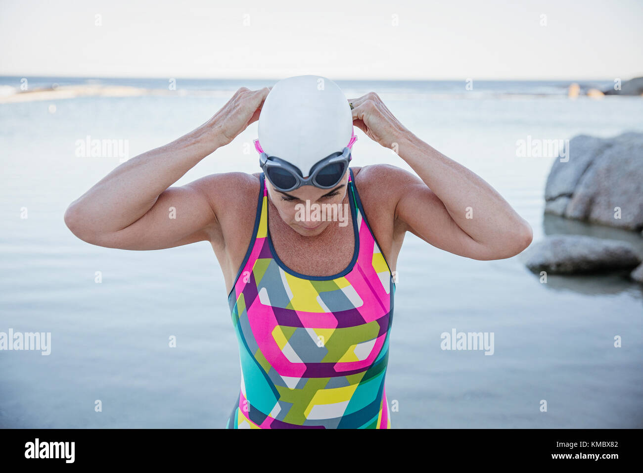 Weibliche Open water Schwimmer einstellen Schwimmbrille im Ocean Stockfoto