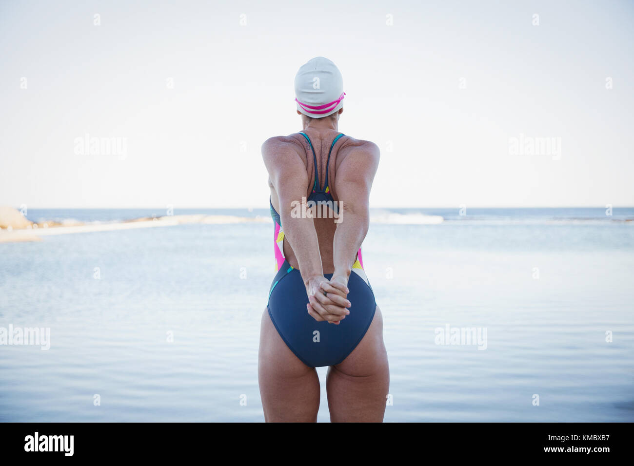Schwimmerin im offenen Wasser, die die Arme am Meer streckt Stockfoto