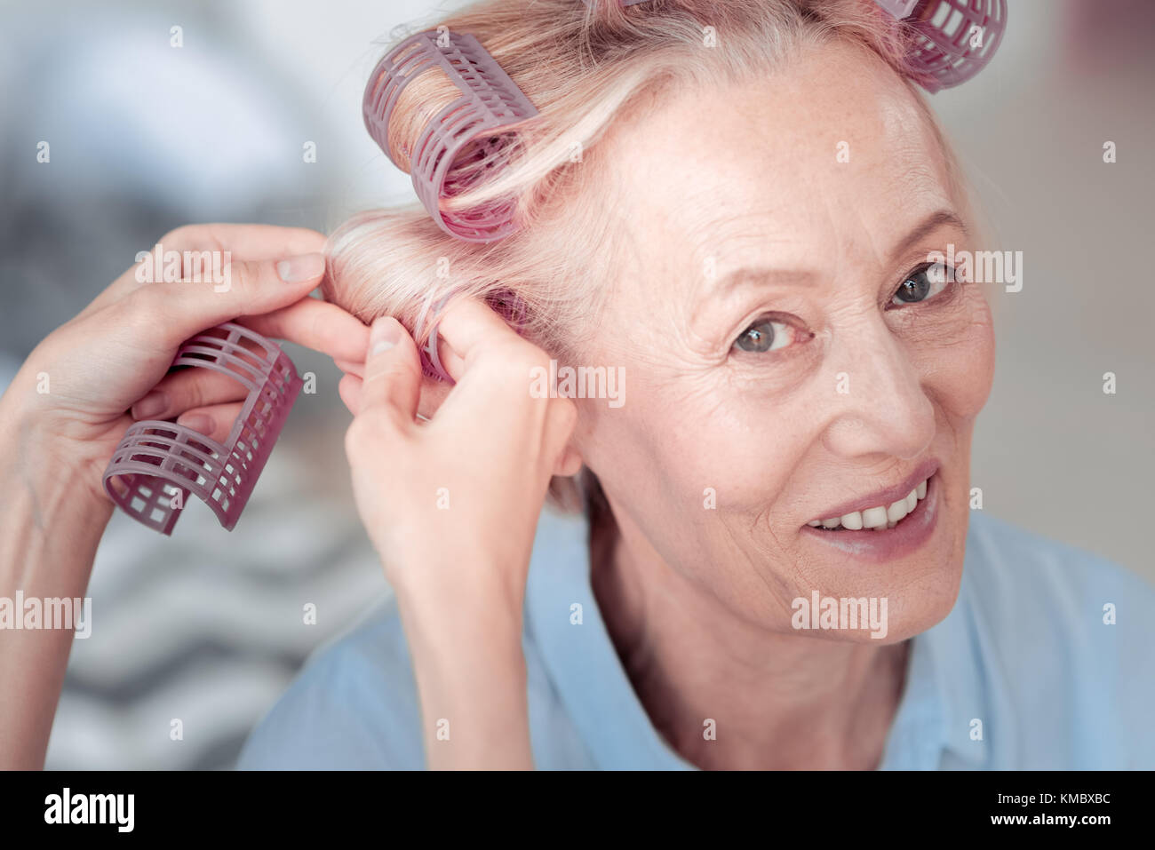 Freut mich, Frau mit Haar Rollen Stockfoto