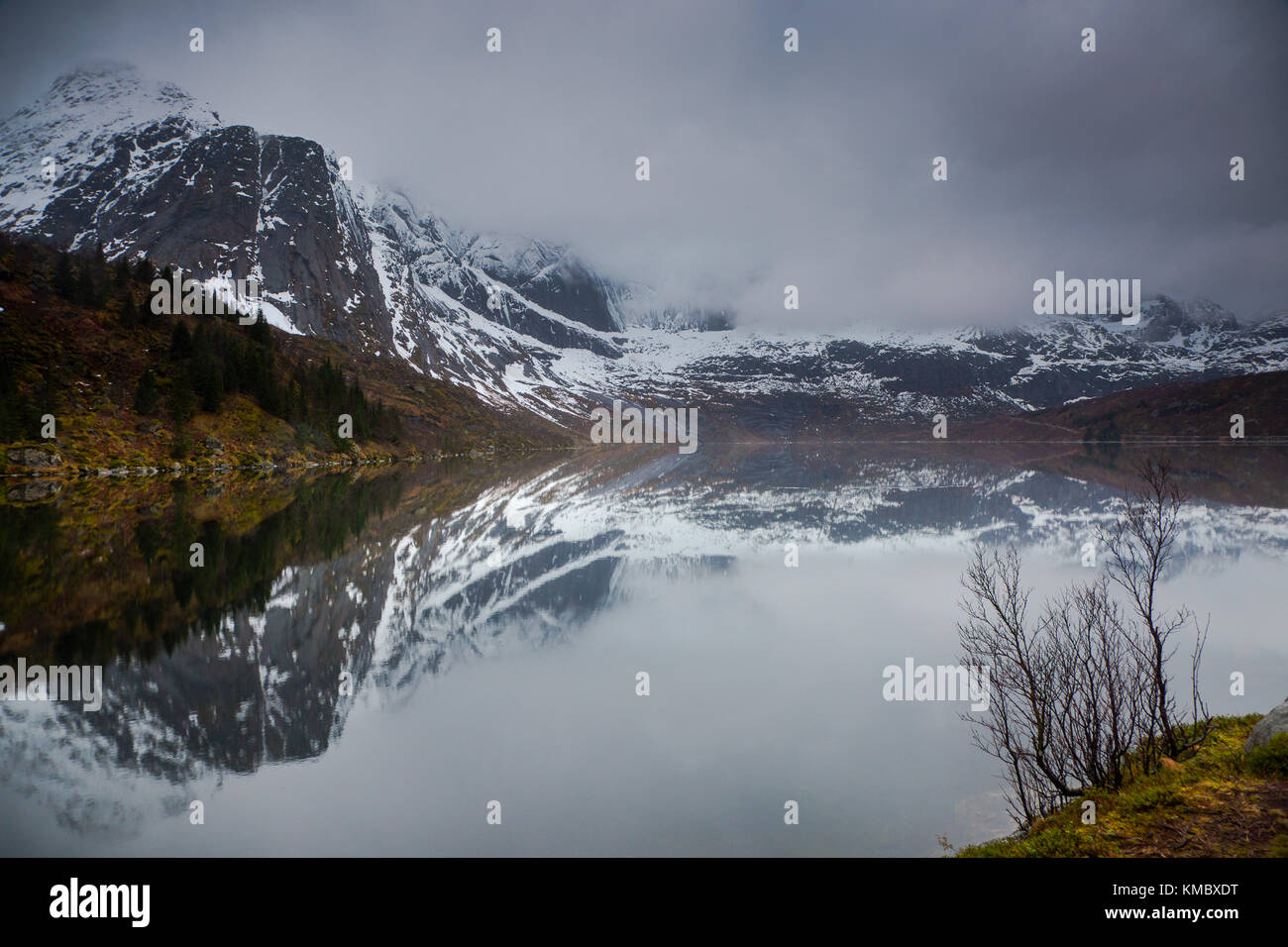 Spiegelung von verschneiten, zerklüfteten Bergen im Wasser, Storvatnet, Lofoten, Norwegen Stockfoto