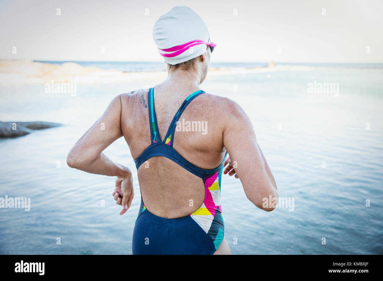 Schwimmerin im offenen Wasser, die ins Meer läuft Stockfoto