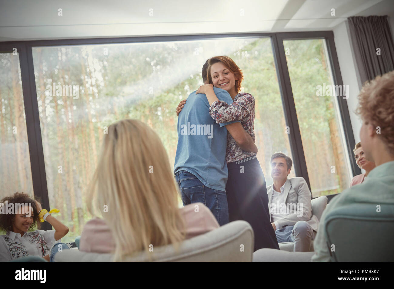 Mann und Frau umarmen in Gruppe Therapie Sitzung Stockfoto