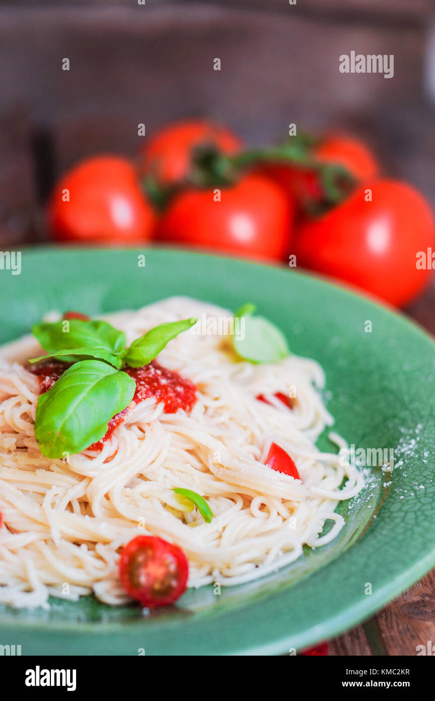 Spaghetti mit Tomaten und Basilikum auf hölzernen Hintergrund Stockfoto