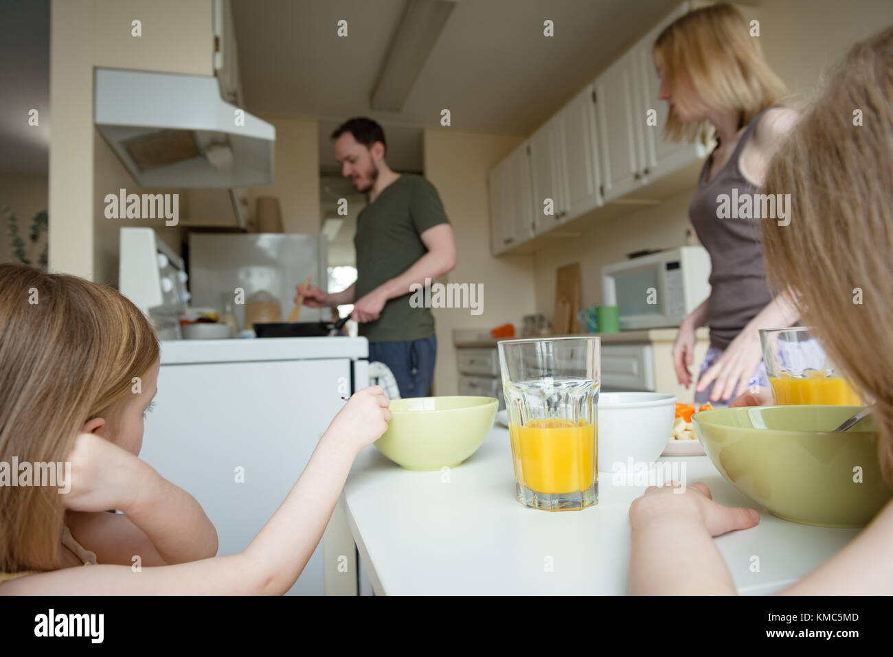 Vater, Mutter und Tochter, die an der Zubereitung der Speisen in der Küche auf der Suche Stockfoto