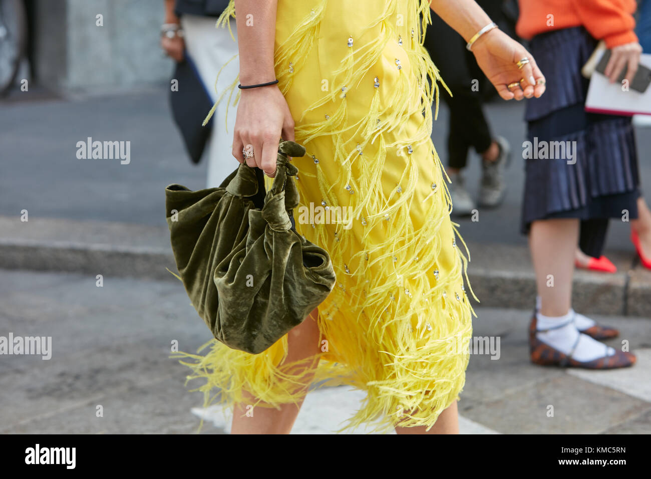 Mailand - 23. September: Frau gehen mit gelben Kleid mit Federn Fransen und grün Samtbeutel vor Antonio marras fashion show, Mailand fashion Wee Stockfoto