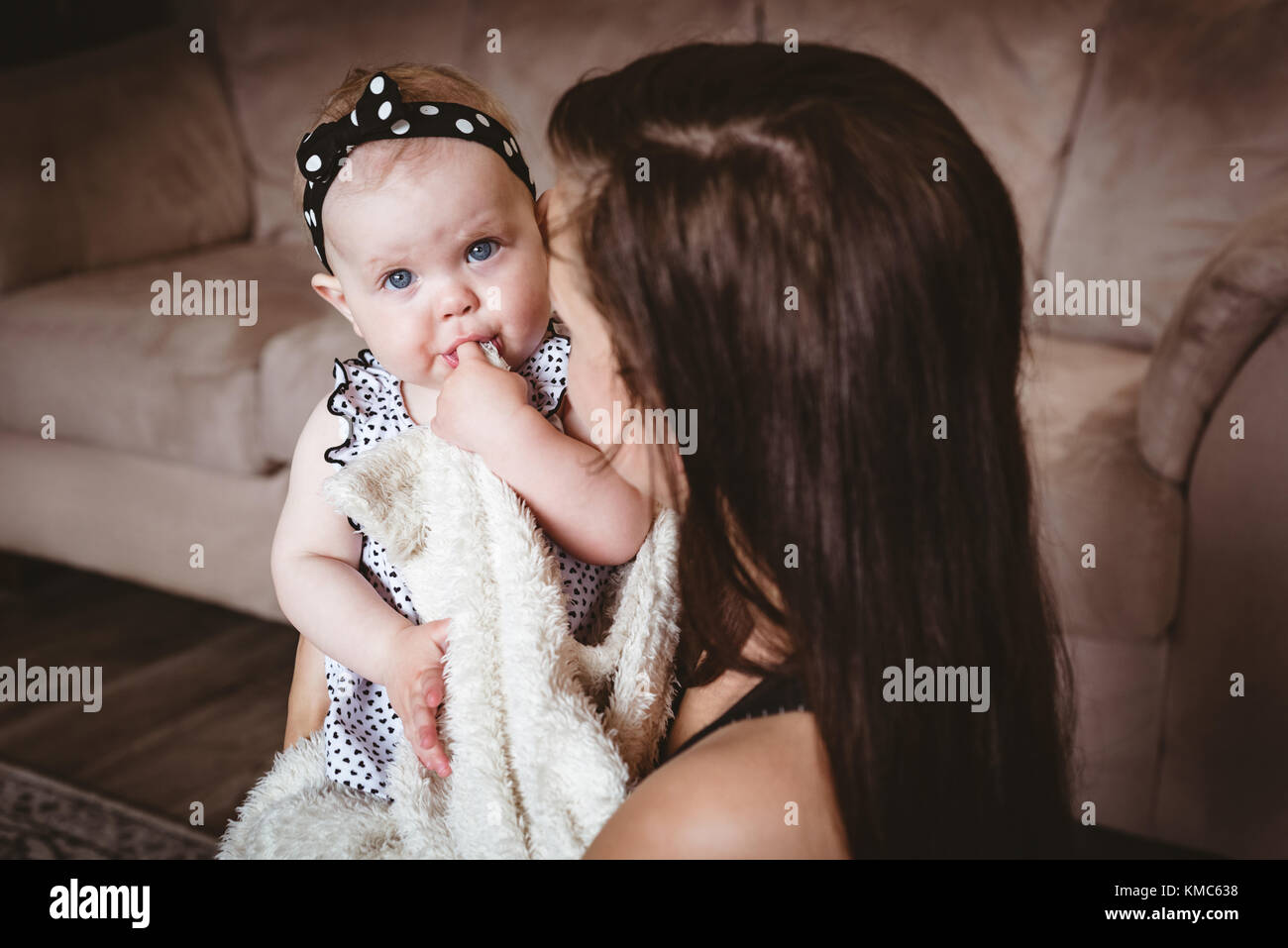 Mutter ihr Baby Holding im Wohnzimmer Stockfoto