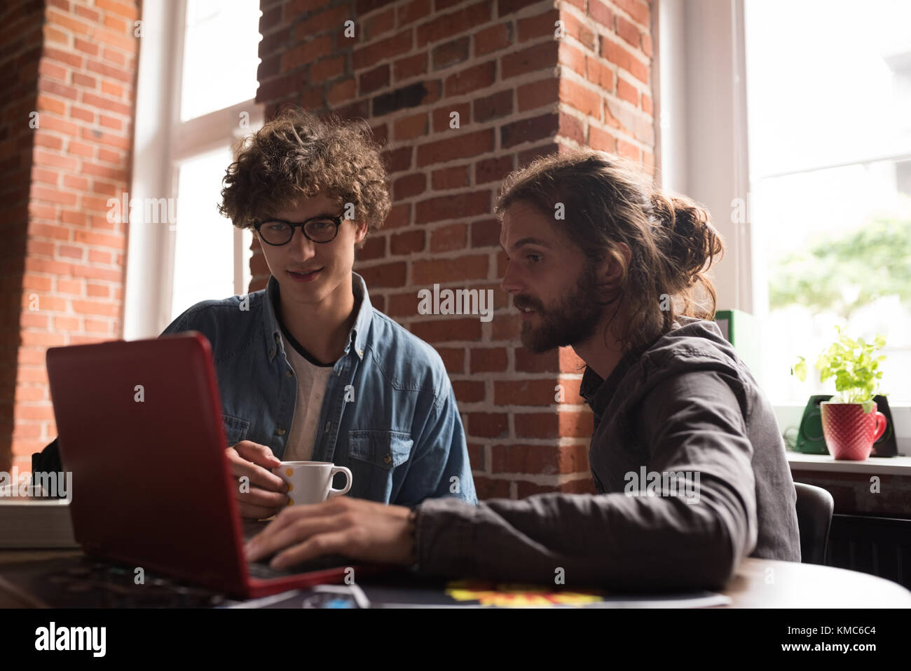 Männliche Führungskräfte diskutieren über Laptop Stockfoto