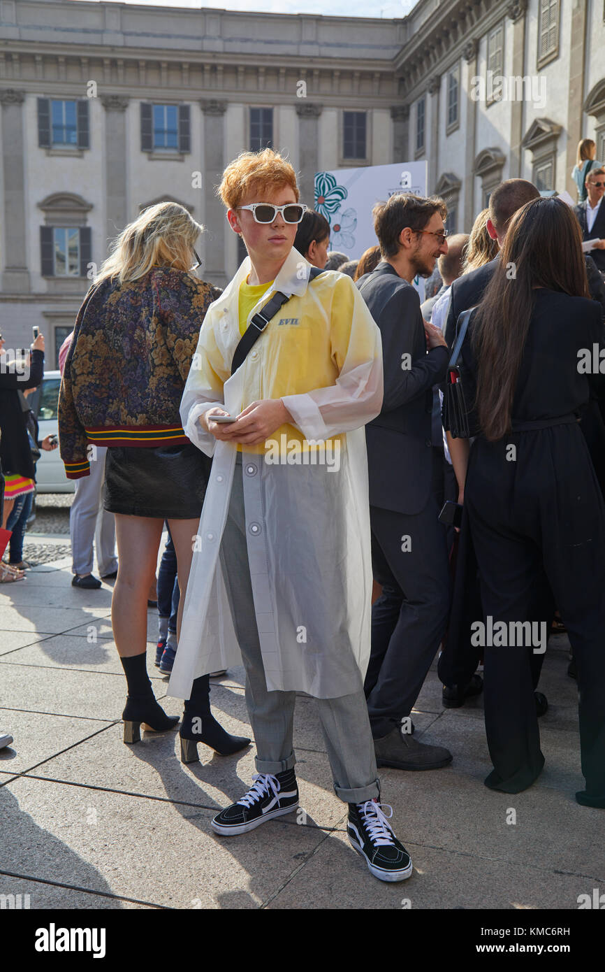 MAILAND - 23. SEPTEMBER: Gast mit transparentem Regenmantel und schwarzen und weißen Vans-Schuhen vor der Gabriele Colangelo Modenschau in der Mailand Fashion Week Street Stockfoto