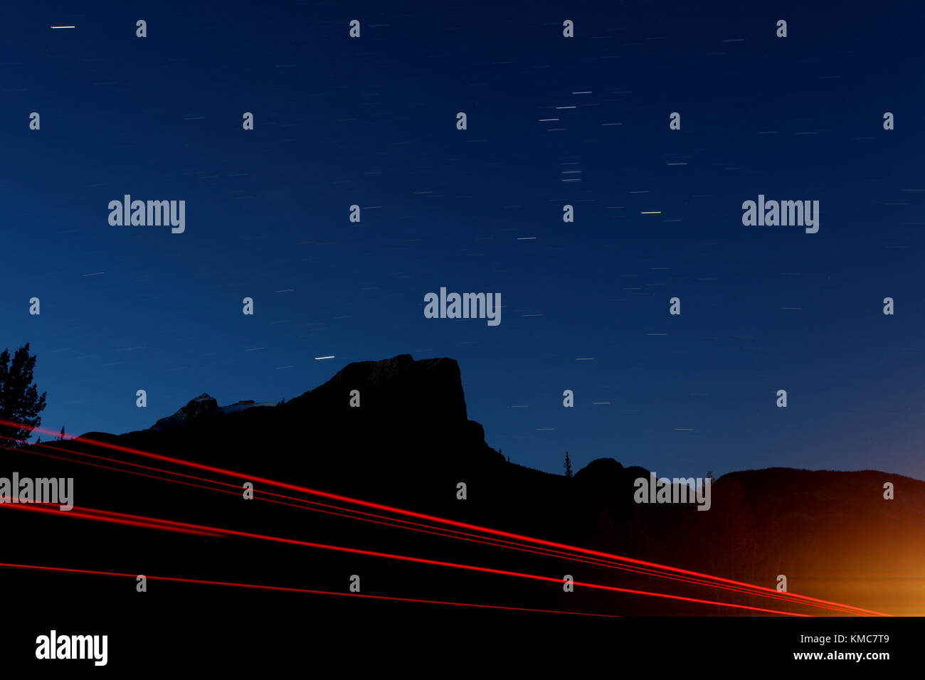 Star Trails, Berge Silhouette und Lkw schwänze Lichter entlang der Trans Canada Highway Stockfoto
