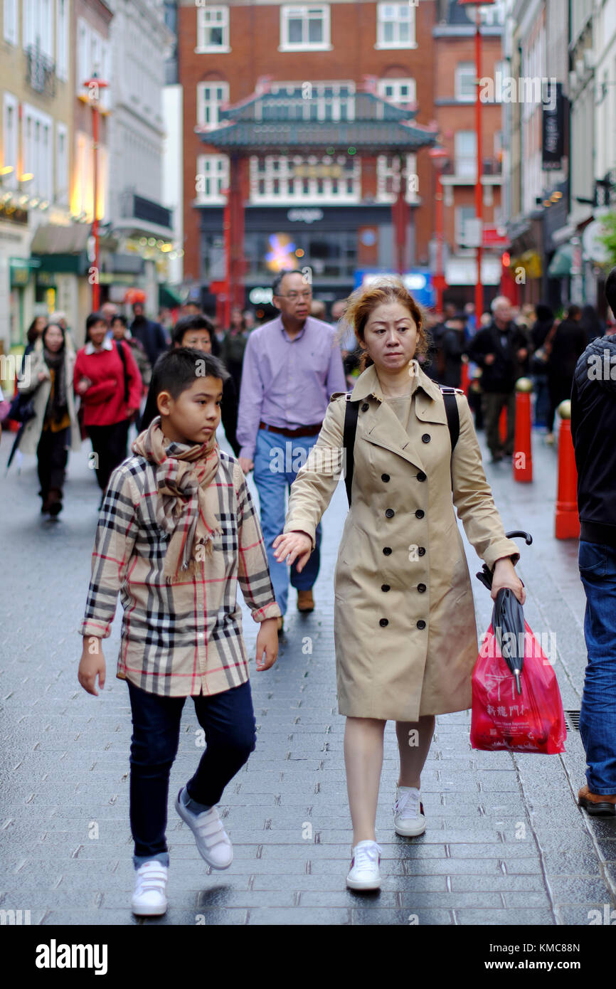 Chinesische Mutter mit Sohn, beide trugen Burberry Kleidung in Chinatown, Soho, London, England, Großbritannien Stockfoto