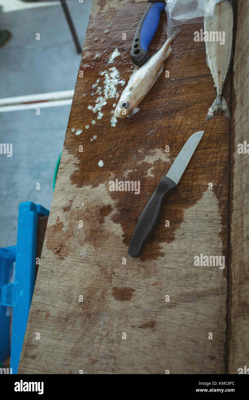 Enthäutete Fisch und Messer auf Holz- Arbeitsfläche Stockfoto