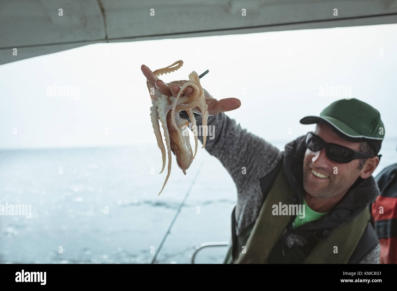 Fischer hält Kraken Stockfoto