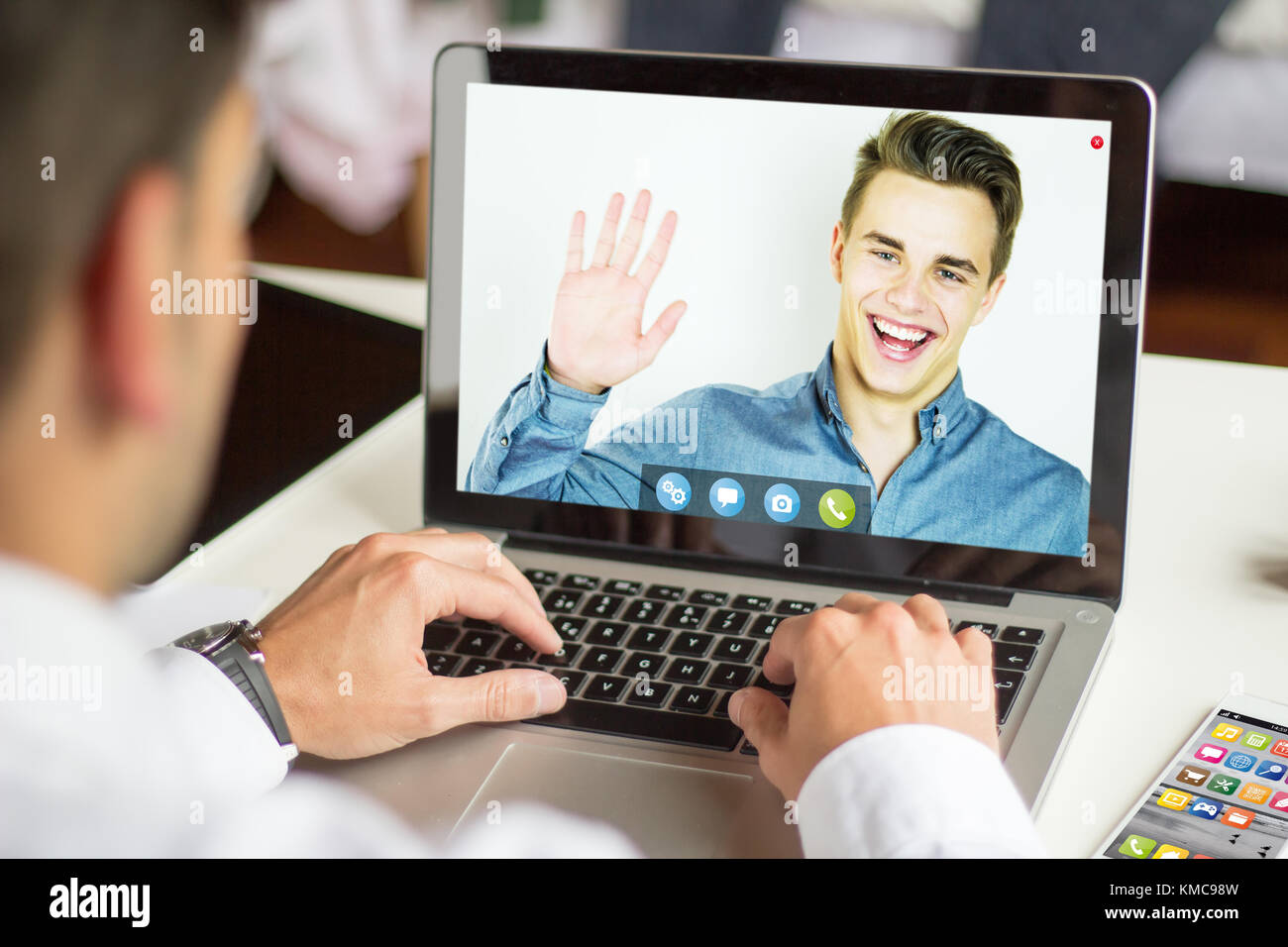Unternehmer im Gespräch mit video chat APP mit einem Laptop, alle Grafiken bestehen. Stockfoto