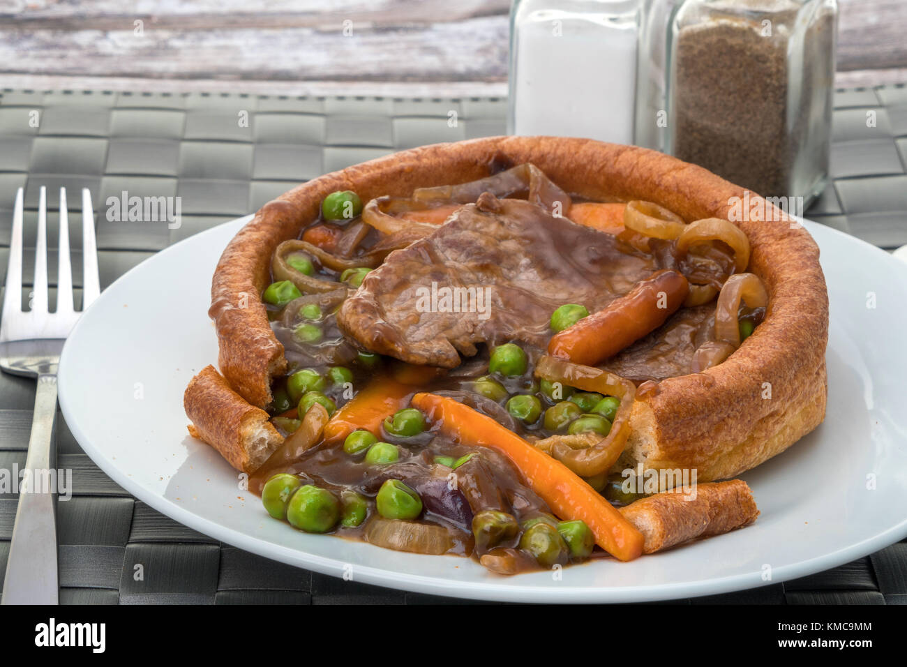 Ein gefüllter Yorkshire-Pudding mit geschnittenem Rindfleisch, Gemüse und einer dicken Soße. Stockfoto